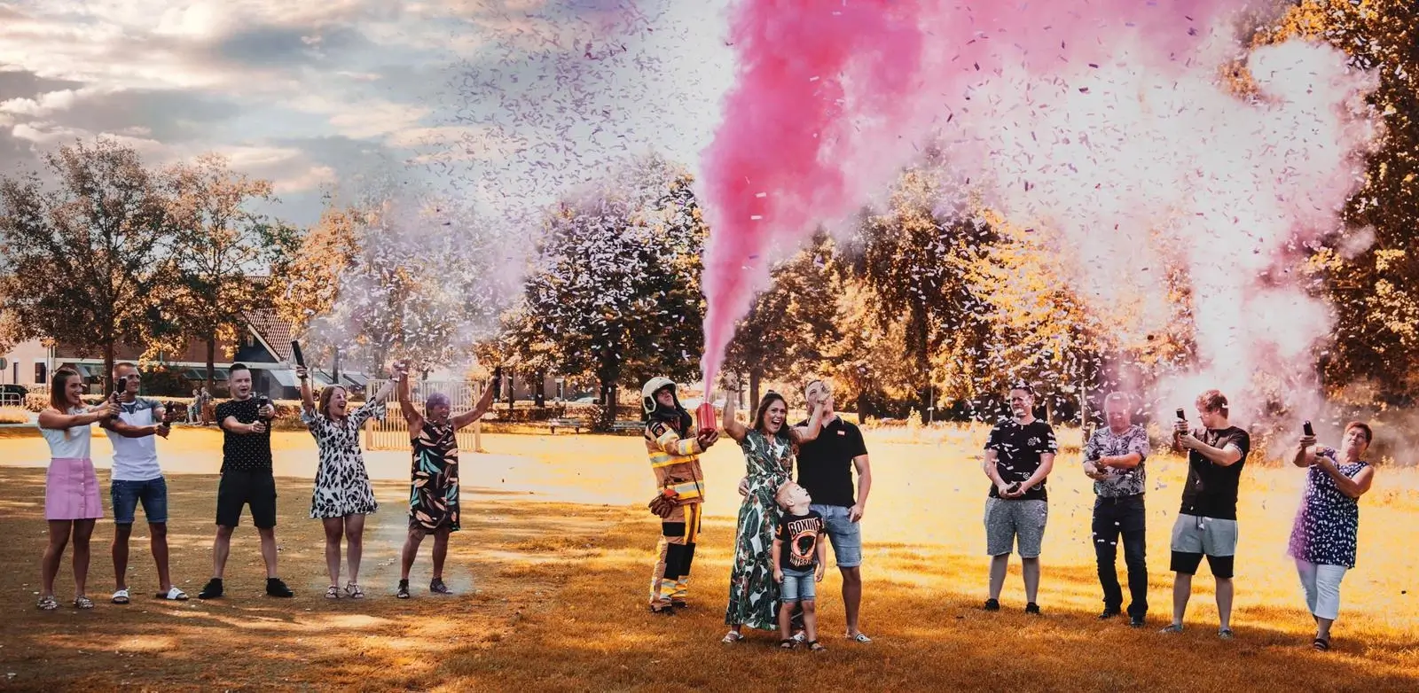 Gemeinsamer Gender Reveal mit rosa Farbpulver und Konfetti